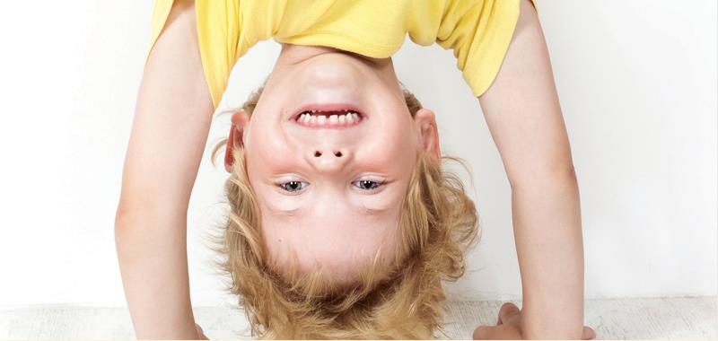 Boy in yellow shirt doing a hand stand