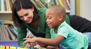 A teacher counting colorful plastic bears with a student